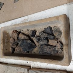 Steingefäß mit Kohlestücken